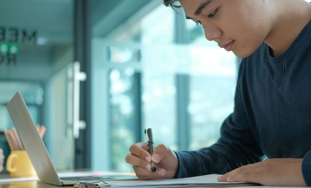 Image of an international student writing his university application.