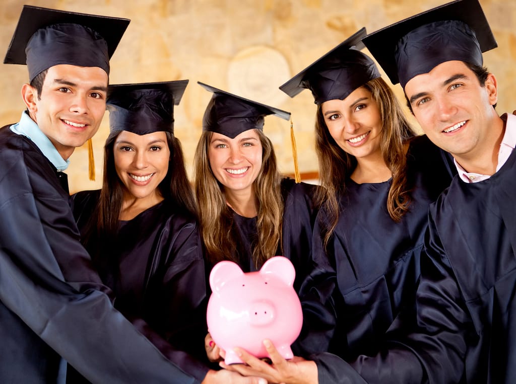 Picture of graduating international students with a piggy bank showing the availability of low cost education in Finland.
