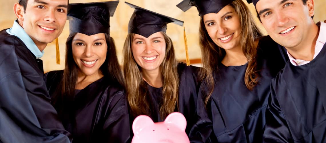Picture of graduating international students with a piggy bank showing the availability of low cost education in Finland.